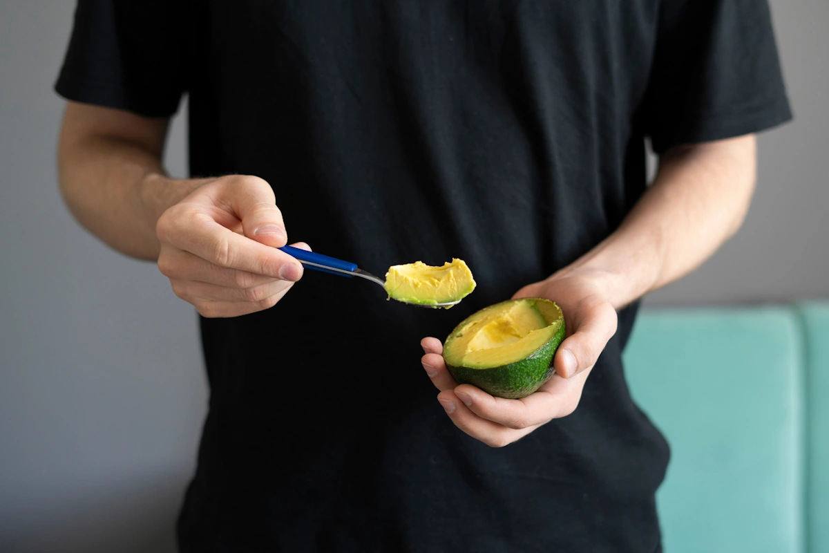 Un homme en période de jeûne 16/8 qui mange un avocat