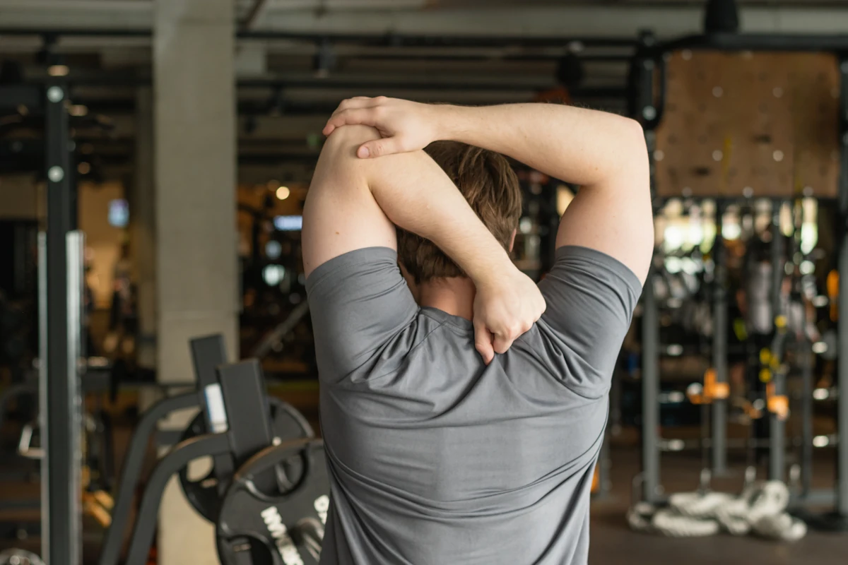 Un homme qui échauffe ses épaules avant un développé couché