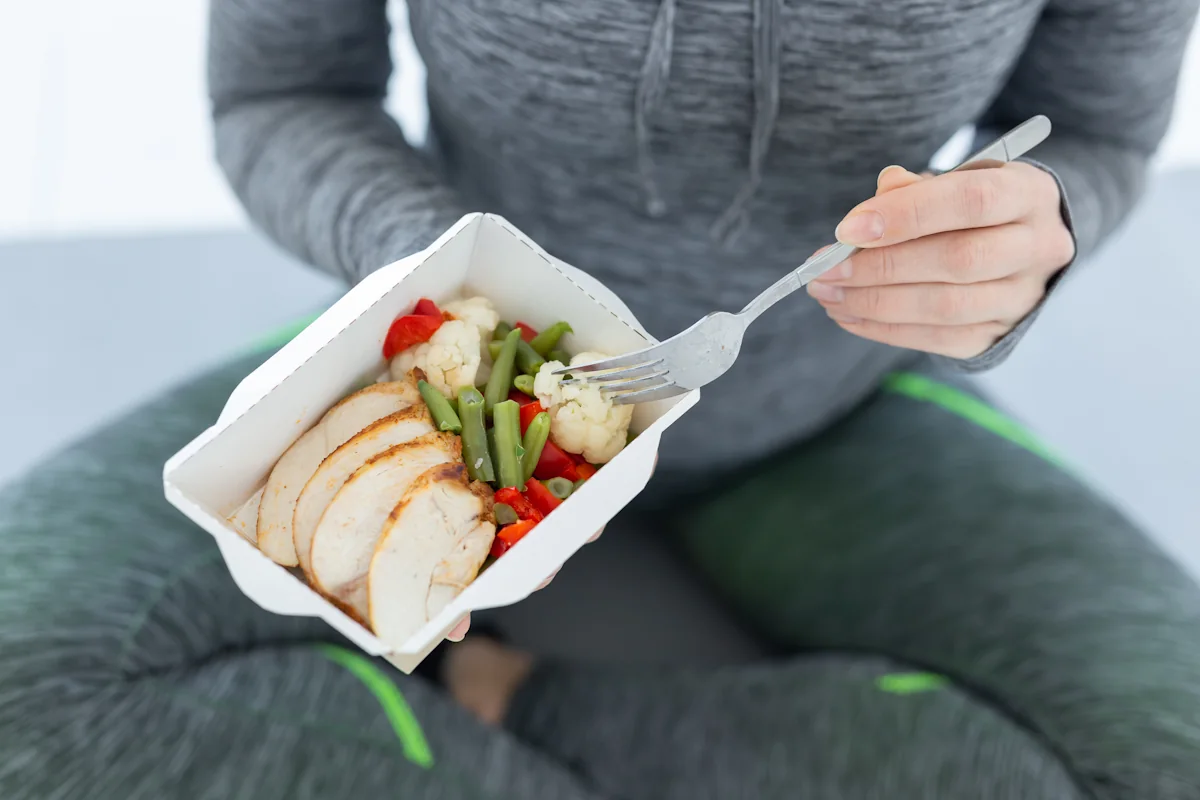 Une femme sportive qui mange de la Viande maigre, protéines et musculation débutant