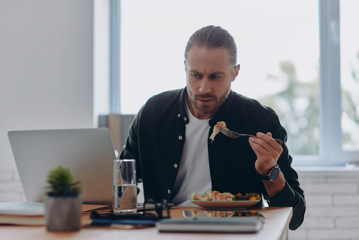 Un homme stressé qui mange à cause du binge eating