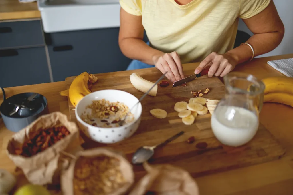 Une personne qui prépare une collation pré-workout banane dattes avoine