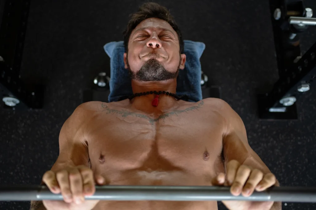 Un homme qui fait un développé couché avec des douleurs à l'épaule