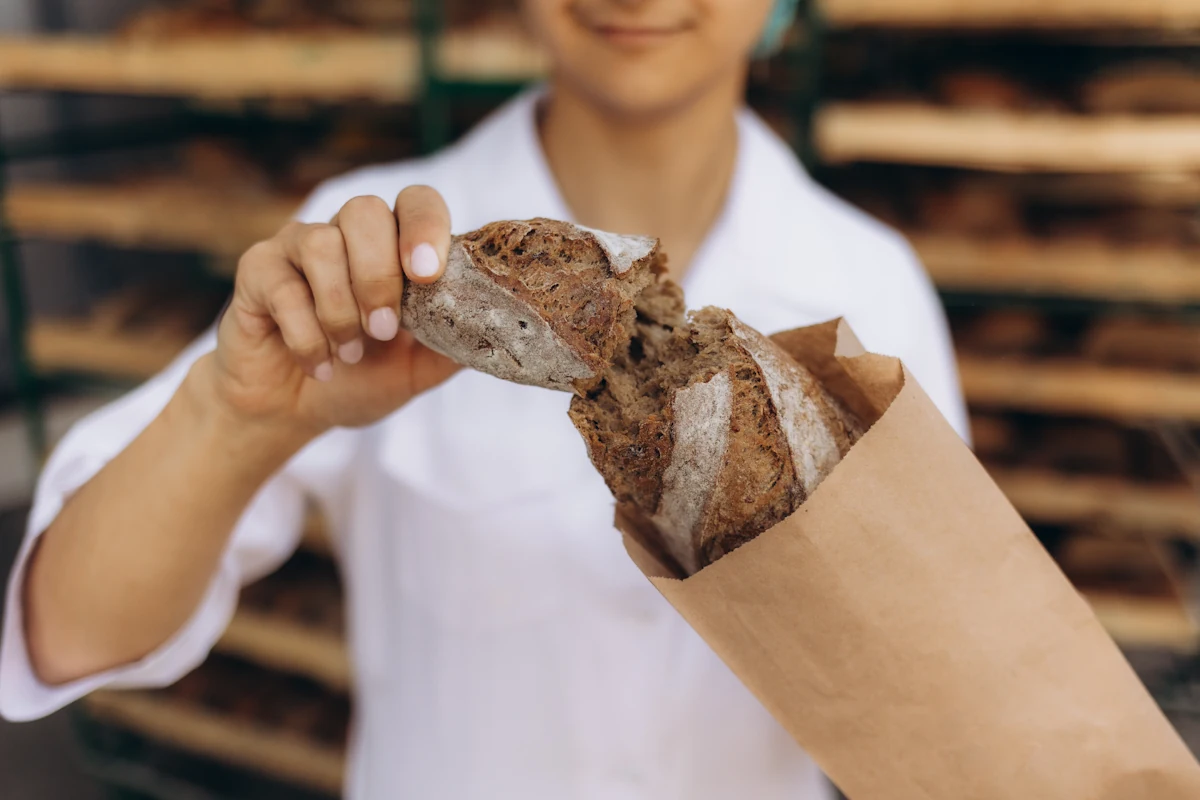 Une personne qui mange du pain complet