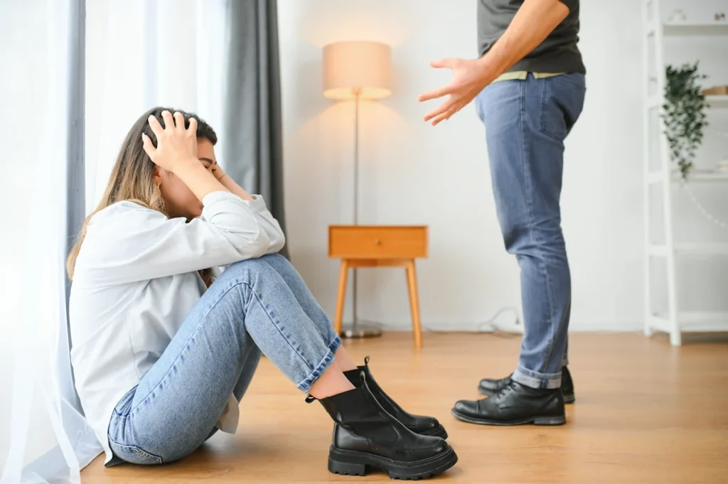 Un pervers narcissique qui se dispute avec sa femme assise sur le sol