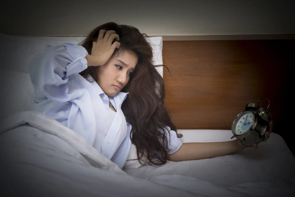 Une femme qui se réveil à 3 heures du matin et qui regarde l'heure